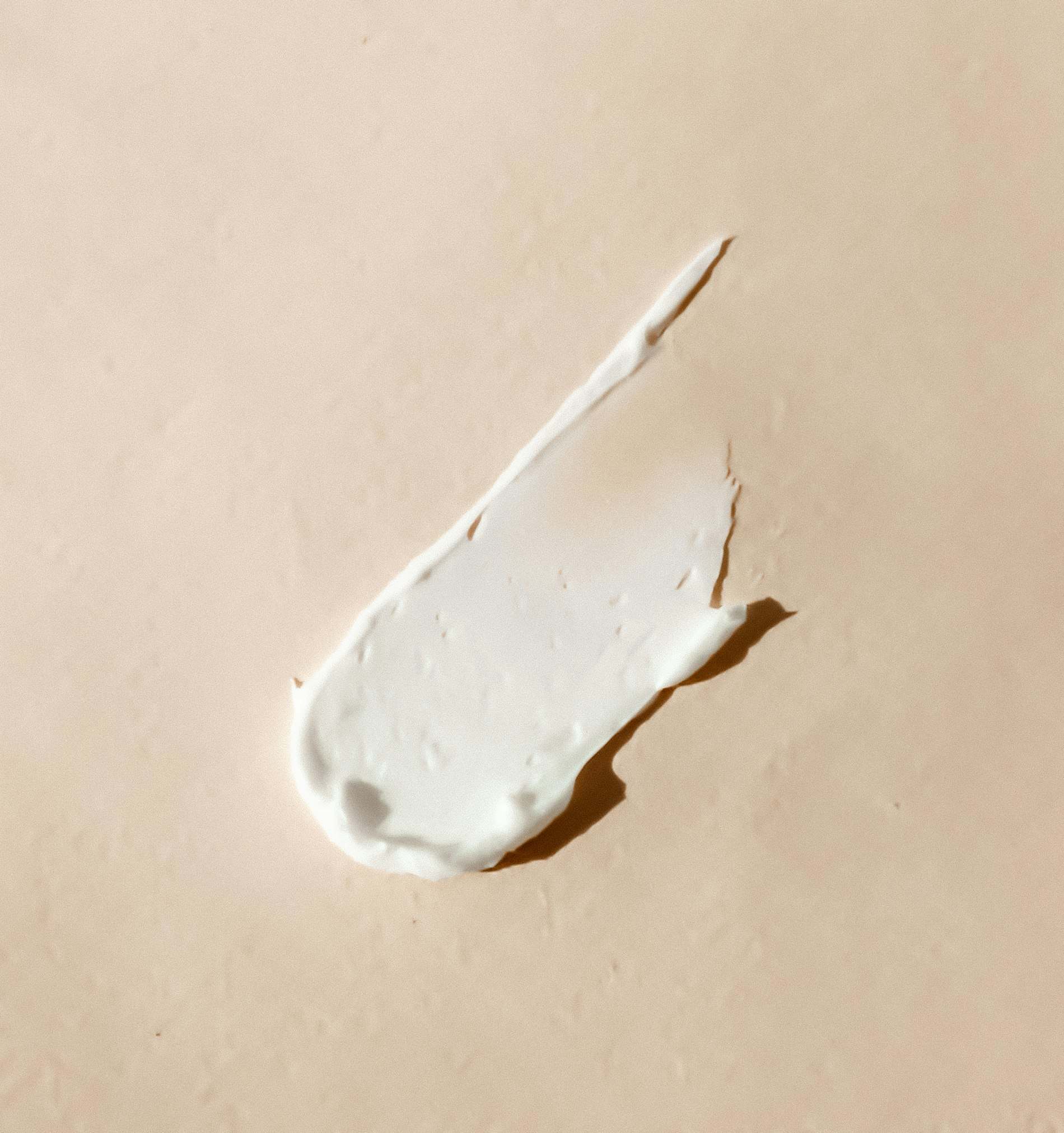 Porção de creme branco espalhada sobre superfície clara